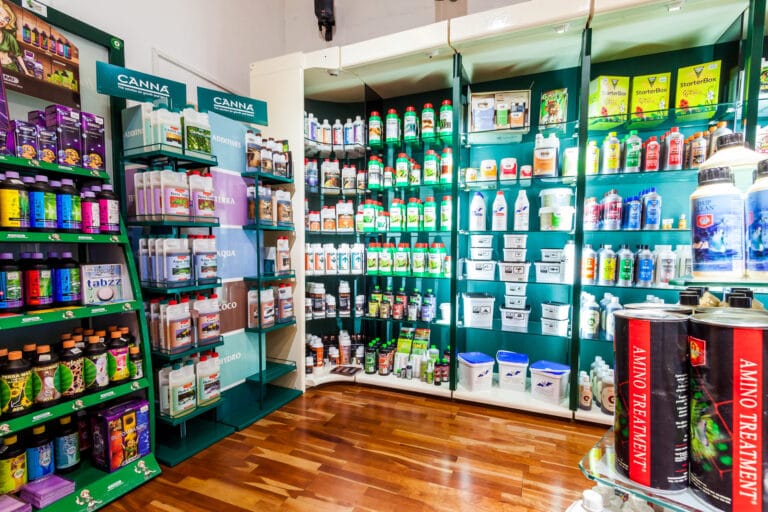 Ecke mit grünen Regalen voller Dünger, vorne das Canna-Regal