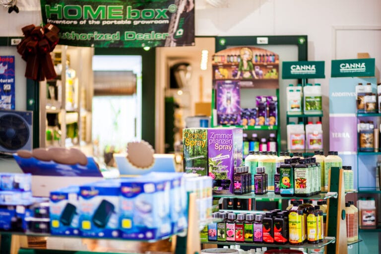 Theke im GrowCologne Growshop, dahinter Regale mit Pflanzensprays und Düngerflaschen.