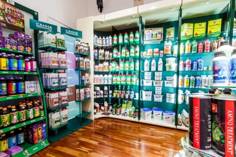 Ecke mit grünen Regalen voller Dünger, vorne das Canna-Regal
